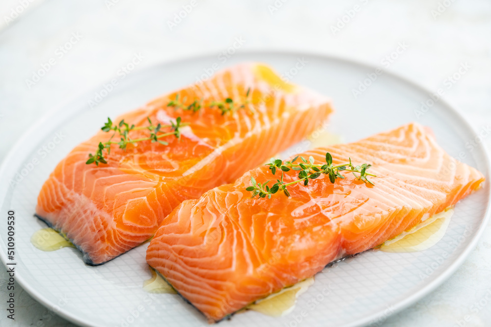 Fresh salmon fillet with herbs on a plate for delicious salmon steak. Fresh salmon fillet with herbs on a plate for delicious salmon steak.