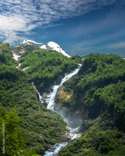 Beautifull high waterfall in mountains with green forest