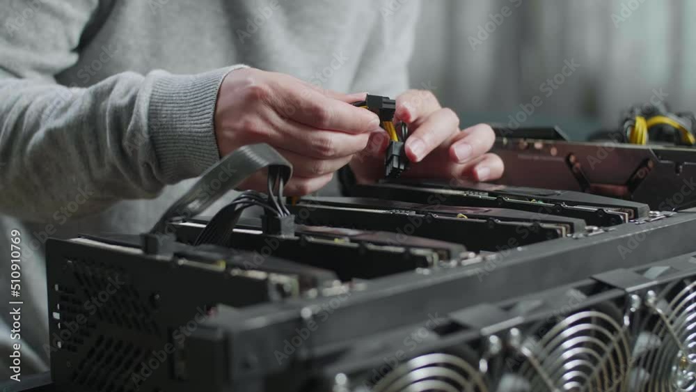 Close Up Of Man'S Hands Connect The Power Cords Of Mining Rig For Mining Cryptocurrency
Close Up Of Man'S Hands Connect The Power Cords Of Mining Rig For Mining Cryptocurrency
