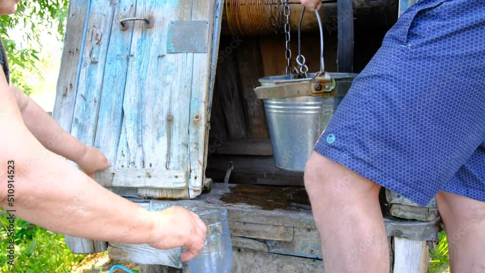 Ancient well with clean water. Ecology, getting water. The man turns