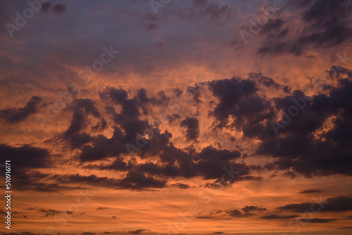 The evening sky is bathed in warm, orange sunlight. The evening sky with light clouds is lit with orange, Martian light. Large photo. Photo of sky for background or texture. The sky looks like a Marti