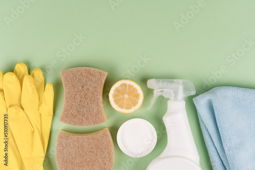 Green household concept. Bio organic detergent products, homemade cleaning detergents. Natural household cleaners  over green background with copy space. Homemade improvised cleaning products photo