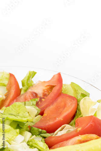 Fresh salad with tomato letuce and paprika served in the bowl with white background