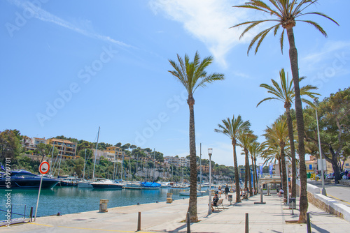 Porto Cristo, Mallorca, Spain - 05.02.2022: Yachts and boats in port of Porto Cristo. Houses on cliffs in background © Abinieks