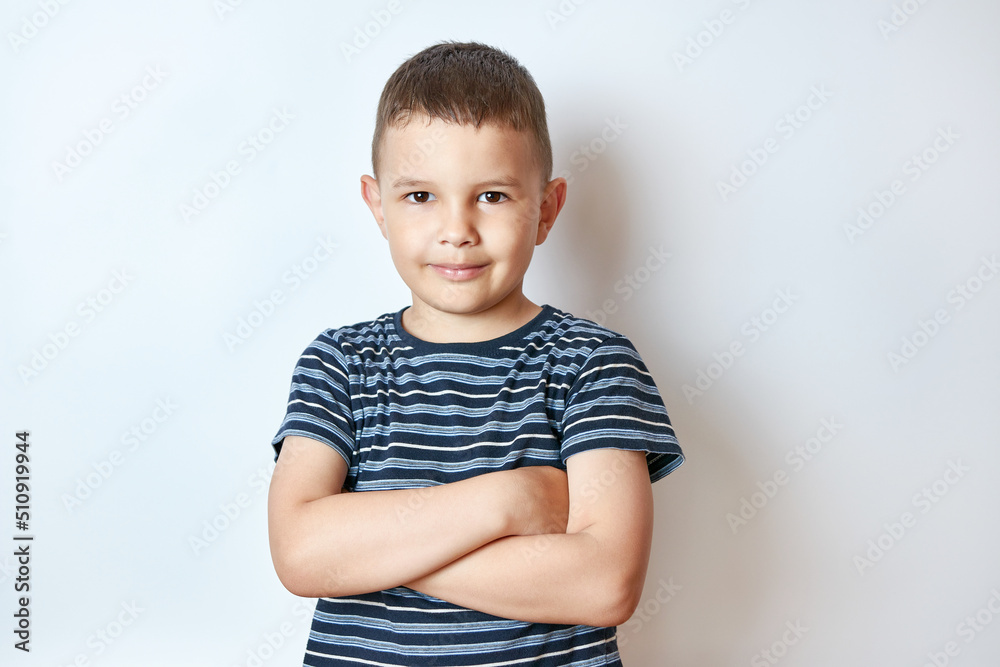 Little smiling boy posing with folded arms. Little smiling boy posing with folded arms.