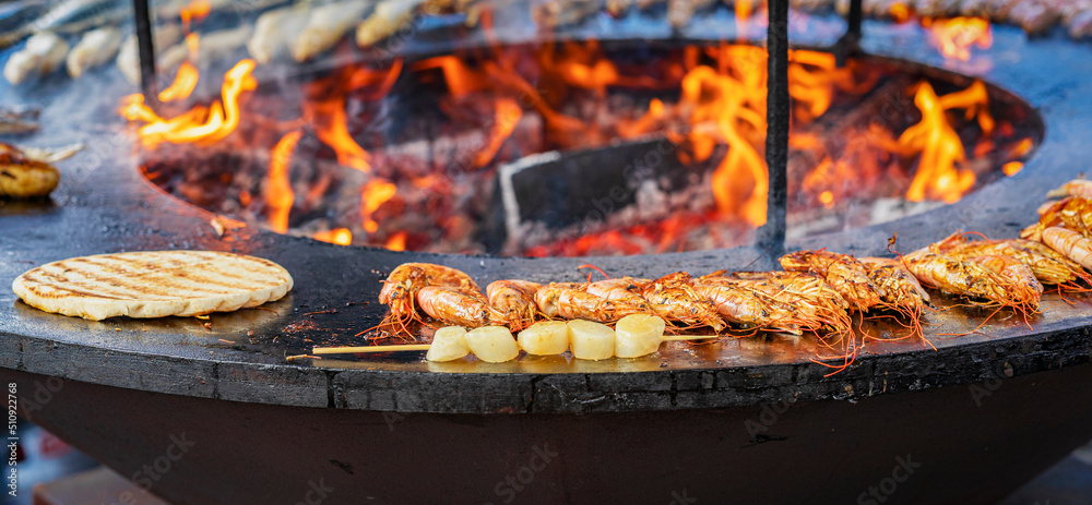 Preparing of seafood outdoors, prepared on bbq grill with fire flame