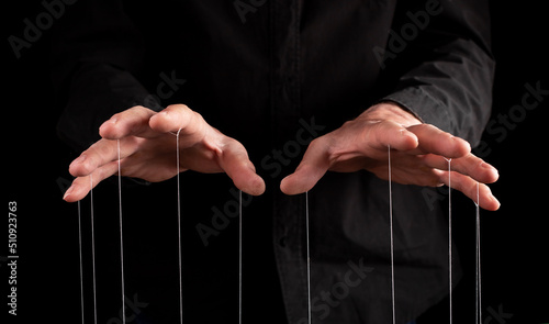 Man hands with strings at fingers. Manipulator controlling, exploiting person, showing power in relationship, at work. Dictatorship. High quality photo photo