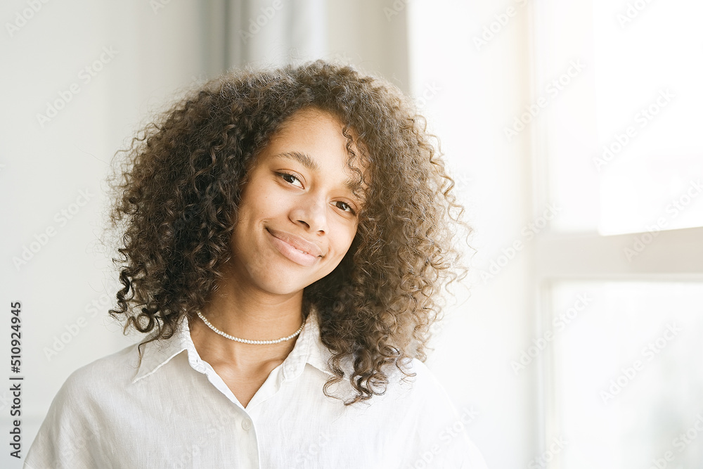 Portrait of a beautiful young woman with black curly hair. African american girl smiling. People, lifestyle, beauty concept Portrait of a beautiful young woman with black curly hair. African american girl smiling. People, lifestyle, beauty concept