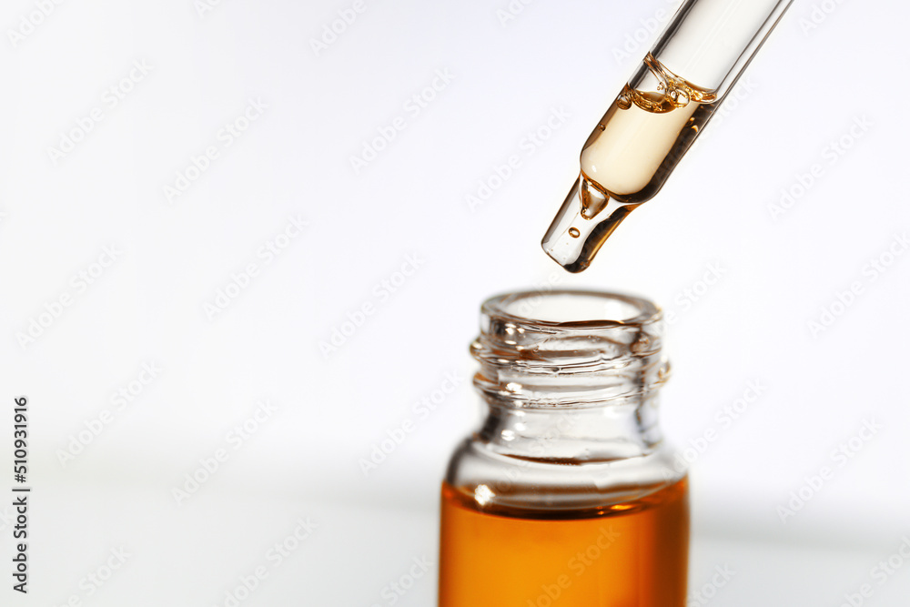Pipette with transparent fluid hyaluronic acid or serum. Cosmetics, science and healthcare concept closeup. Dose of serum or retinol falls in a bottle. Front view. Beauty product presentation, macro Pipette with transparent fluid hyaluronic acid or serum. Cosmetics, science and healthcare concept closeup. Dose of serum or retinol falls in a bottle. Front view. Beauty product presentation, macro
