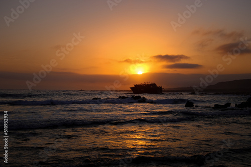 sunset on the beach with shipwreck  © Michaela