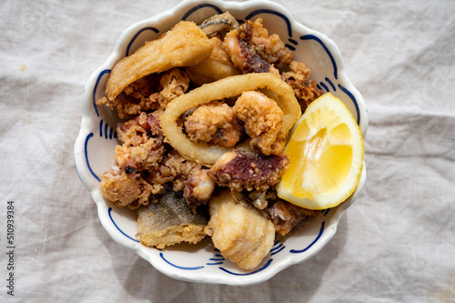 Spanish sea food, cripsy deep fried baby octopus, fish, calamari rings served with lemon photo