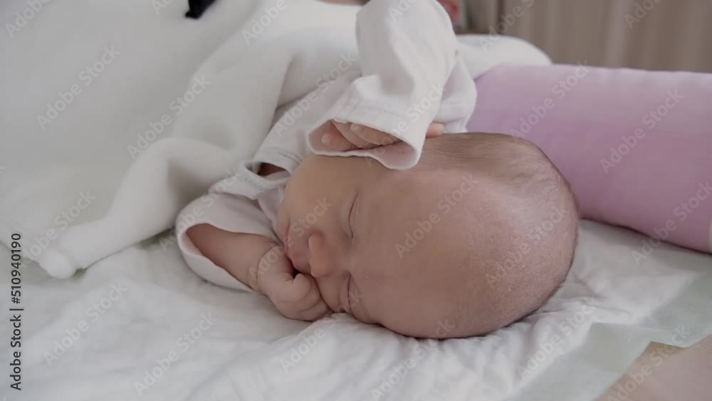 cute little newborn baby girl peacefully sleeps in the nursery on a white cotton bed. selective focus cute little newborn baby girl peacefully sleeps in the nursery on a white cotton bed. selective focus