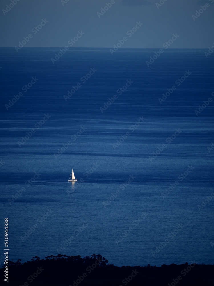 Fototapeta premium Sailboat in the sea, the coast is not too far.