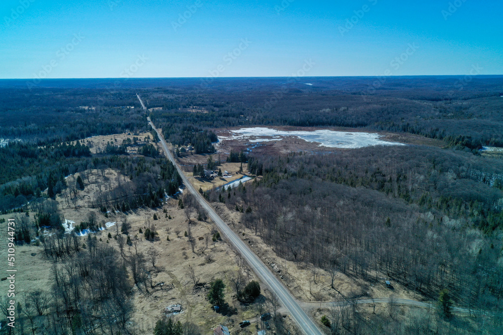 Aerial shot of a country road and a frozen Marsh in the winter