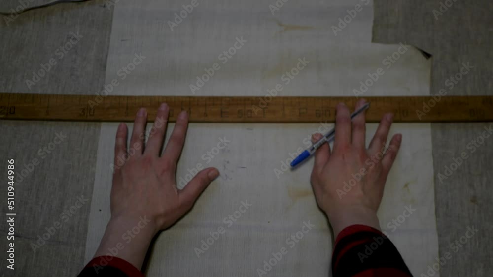 POV of white female seamstress measuring curves on cloth with a large ...