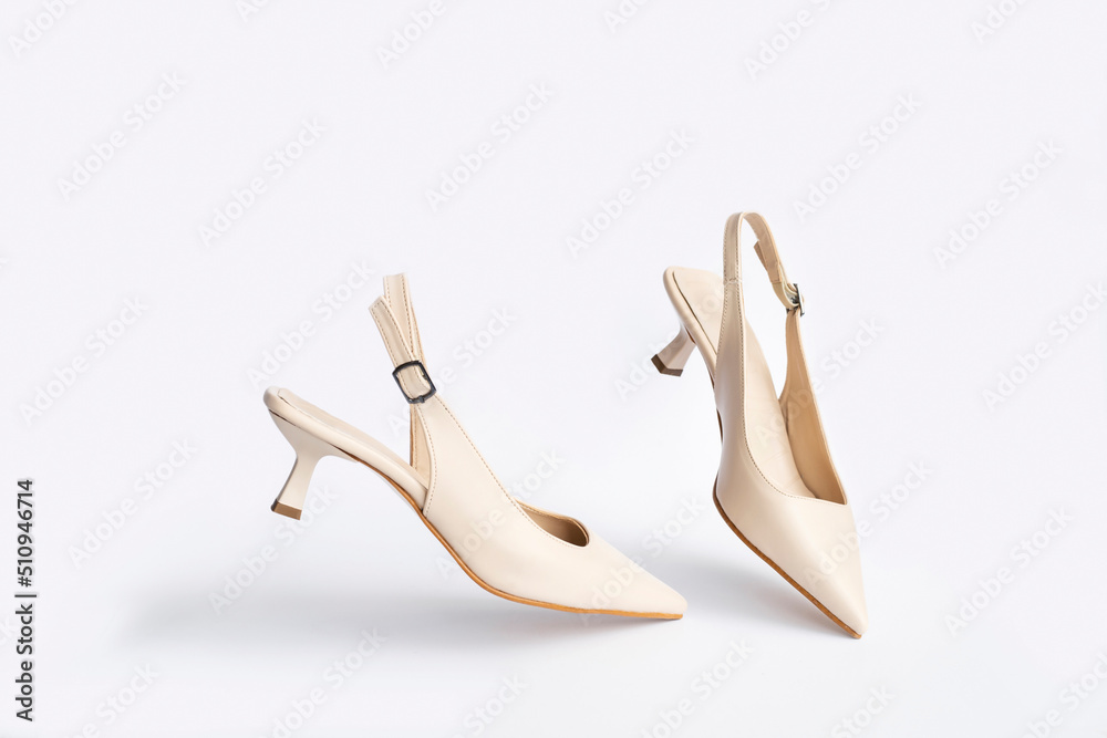 Beige short heels isolated on white background. Fashion concept, catwalk. A modern and trendy shoe store. Beige short heels isolated on white background. Fashion concept, catwalk. A modern and trendy shoe store.