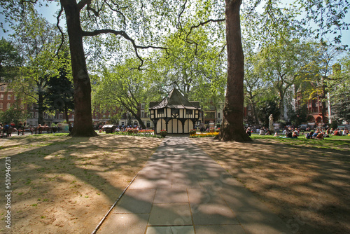 Soho Square in London on a sunny day with people relaxing and sunbathing. photo