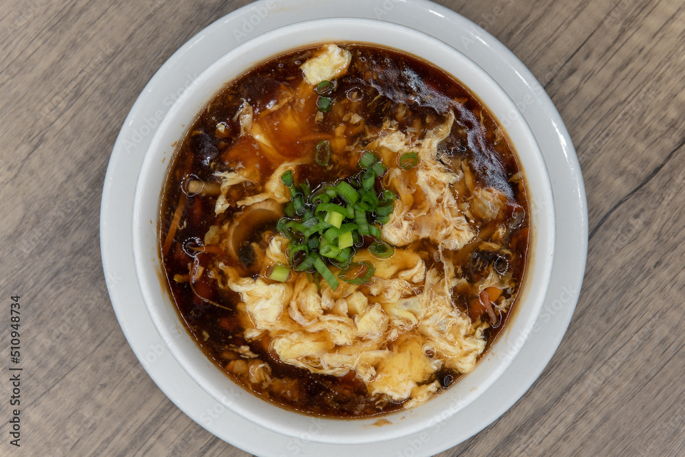 Overhead view of spicy and generous bowl of hot and sour soup for a hearty Chinese food meal Overhead view of spicy and generous bowl of hot and sour soup for a hearty Chinese food meal