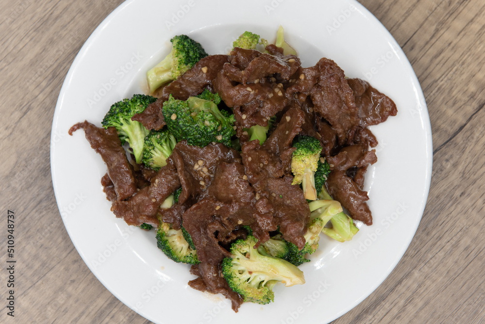Overhead view of beef and broccoli glazed in savory sauce and piled high on the plate for a great Chinese food meal