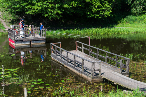 Grobina, Latvia - Juny 11, 2022: People on a wooden ferry. photo