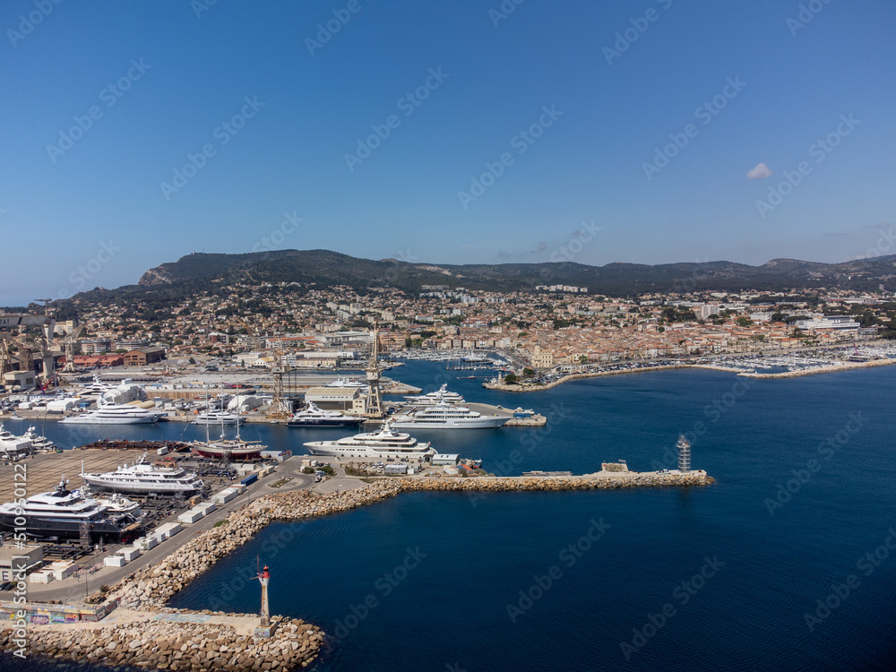 Panoramic aerial view on historical coastal Provencal city La Ciotat with large sailboat harbour and yacht shipyard, summer vacation in Provence, France