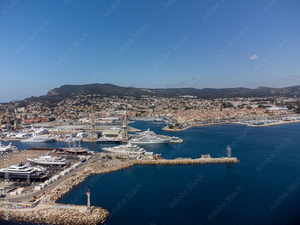 Obraz premium Panoramic aerial view on historical coastal Provencal city La Ciotat with large sailboat harbour and yacht shipyard, summer vacation in Provence, France