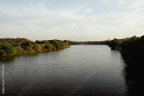 Large river with clear water, banks with green riparian forest and cloudless blue sky - Rio Mogi Guacu - Pontal e Pitangueiras - Sao Paulo - Brazil