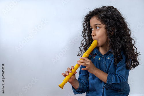 Latin American girl playing with skill the soprano recorder photo