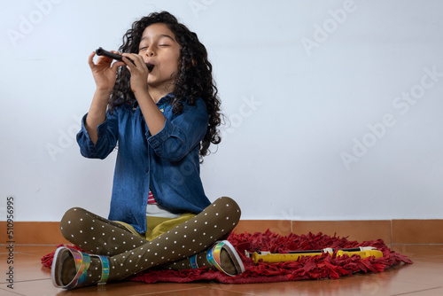 Latin American girl plays the piccolo recorder photo