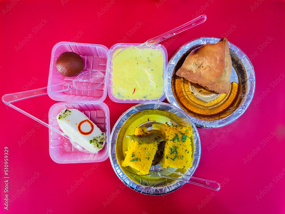 delicious indian sweets with samosa with red background from different