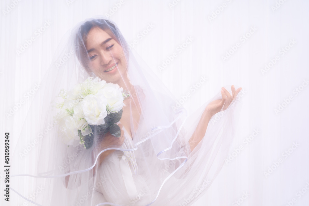 asian bride in white gown with veil holding flower bouquet asian bride in white gown with veil holding flower bouquet