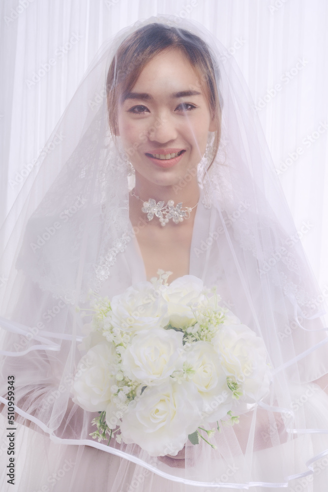 asian bride in white gown with veil holding flower bouquet asian bride in white gown with veil holding flower bouquet
