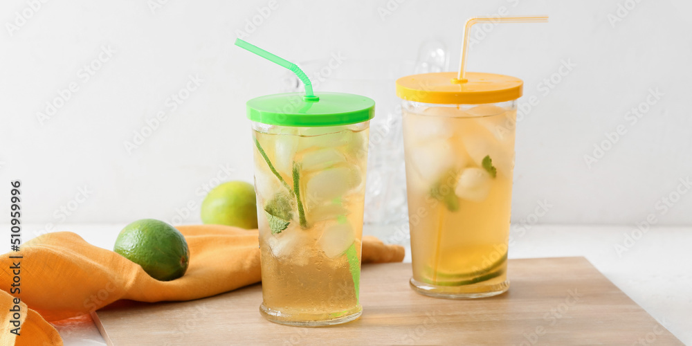 Fototapeta premium Glasses of tasty cold ice tea on light background