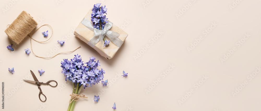 Composition with bouquet of beautiful hyacinth flowers and gift box on light background with space for text