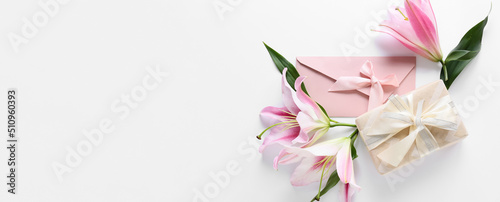 Fototapeta Naklejka Na Ścianę i Meble -  Beautiful lilies, envelope and gift box on white background with space for text