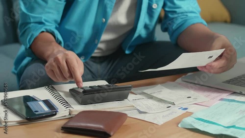Close Up Of Man'S Hand Holding Bill And Calculate Money By Calculator

