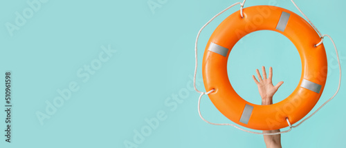 Human hand and lifebuoy on light blue background with space for text photo