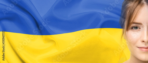 Portrait of pretty young woman against Ukrainian flag. Banner for design