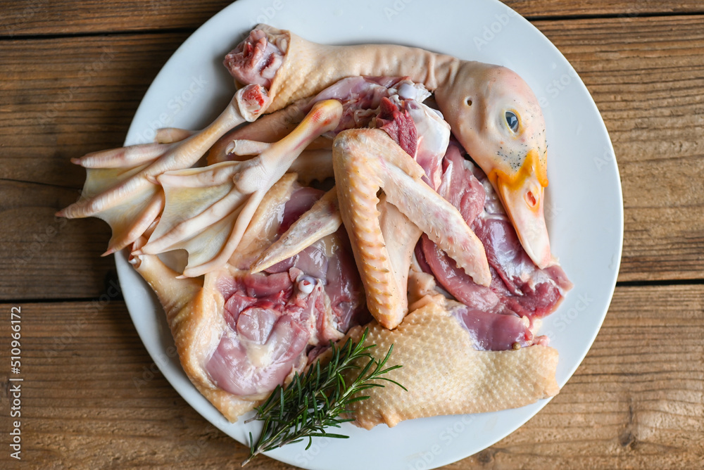 Raw duck breast leg feet wing duck head with spices herb rosemary to cook on white plate, Fresh duck meat for food , poultry meat parts Raw duck breast leg feet wing duck head with spices herb rosemary to cook on white plate, Fresh duck meat for food , poultry meat parts