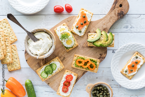 Top down view of everything crackers with various fresh savoury toppings.