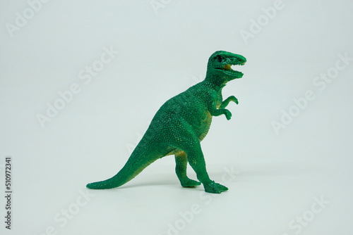 Side view of plastic green Tyrannosaurus rex dinosaur plastic toy for kids, isolated on a studio lighting background photo