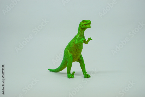 Fototapeta Naklejka Na Ścianę i Meble -  Side view of plastic green Tyrannosaurus rex dinosaur plastic toy for kids, isolated on a studio lighting background