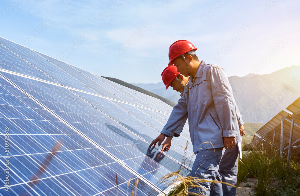 Two asian workers are checking solar photovoltaic outdoors Two asian workers are checking solar photovoltaic outdoors