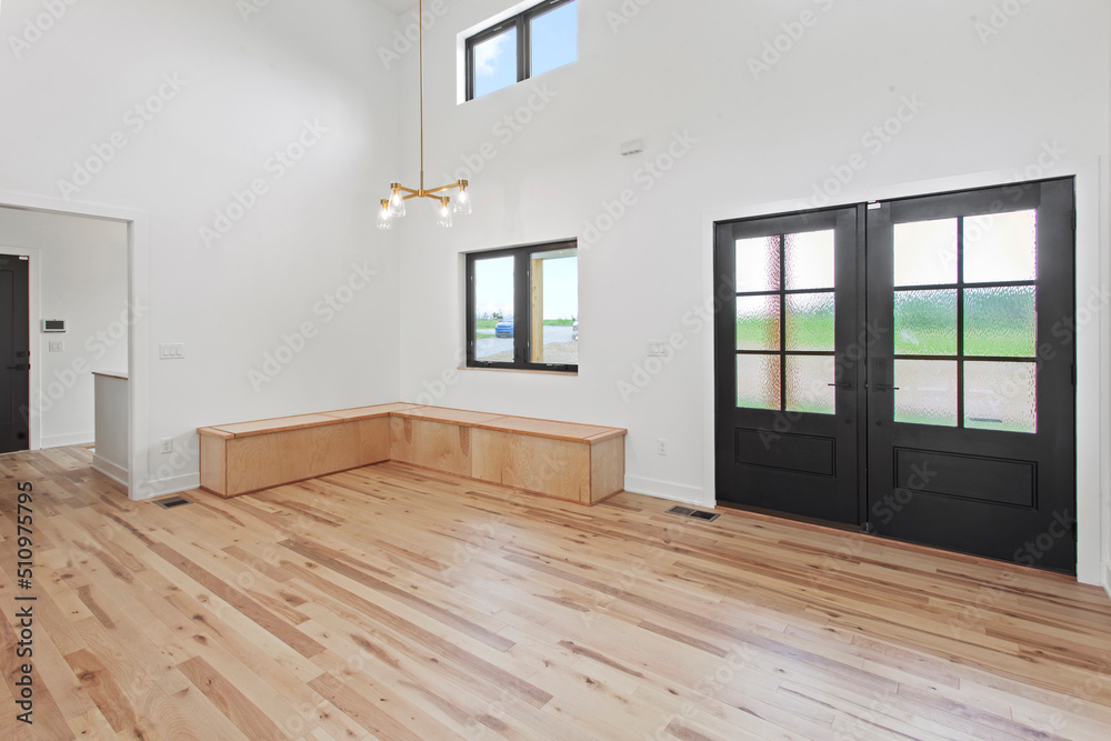 large empty room with black windows and natural finished hardwood flooring large empty room with black windows and natural finished hardwood flooring