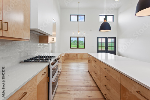 large empty kitchen with black windows and natural finished hardwood flooring