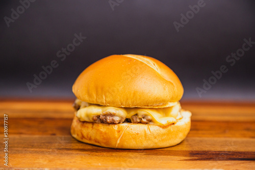 Delicious traditional Brazilian burger, X burger, meat and cheese. on wooden board. photo