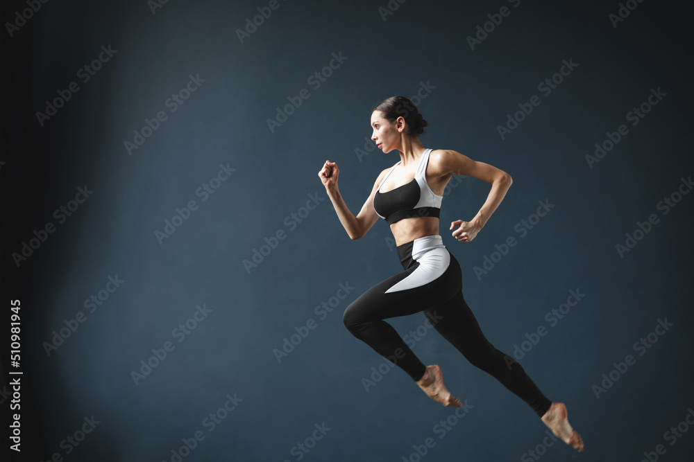 Beautiful athletic woman in a jump posing