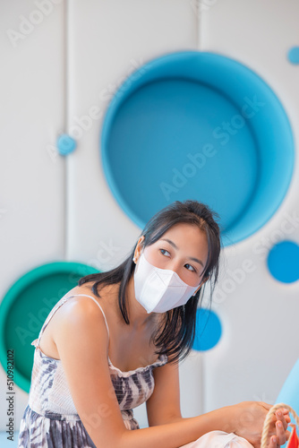 Close-up woman wearing face mask because Air pollution, virus epidemic, flu. Young elegant happy Asian woman put on protective