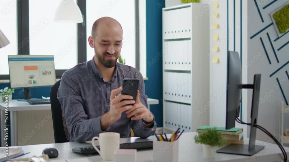 Business man working on financial startegy and checking text message on smartphone, using computer to create sales analysis. Office worker planning executive project for startup growth.
