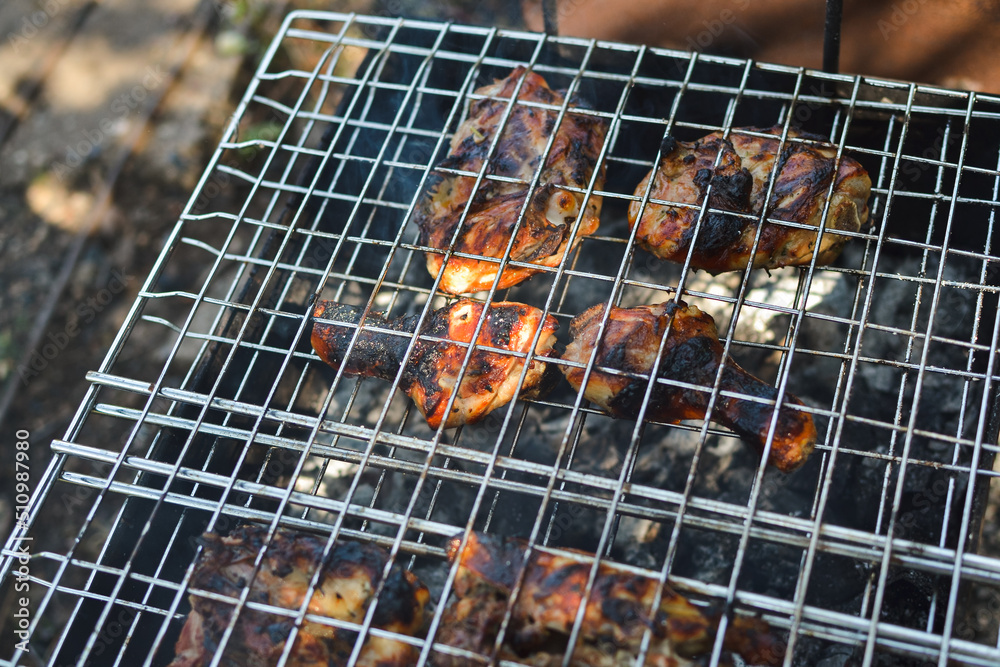 Outdoors top view of chicken meat fried to a crisp on a barbecue grill in the season of holidays and recreation of festivals in nature, selective focus.